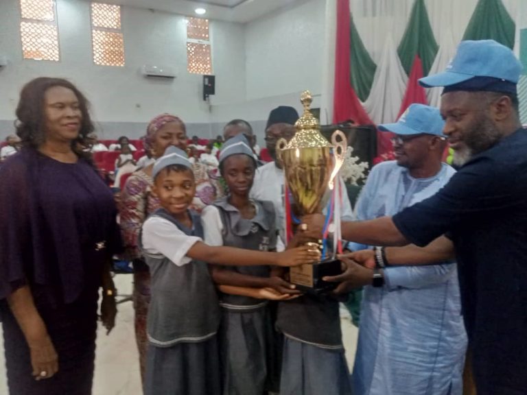 Students of Junior Secondary School (JSS) Karu, the overall winner of the 2023 Head-to-Head Reality House challenge, organised by the Universal Basic Education Board of the Federal Capital Territory(FCT-UBEC) being presented with trophy.
