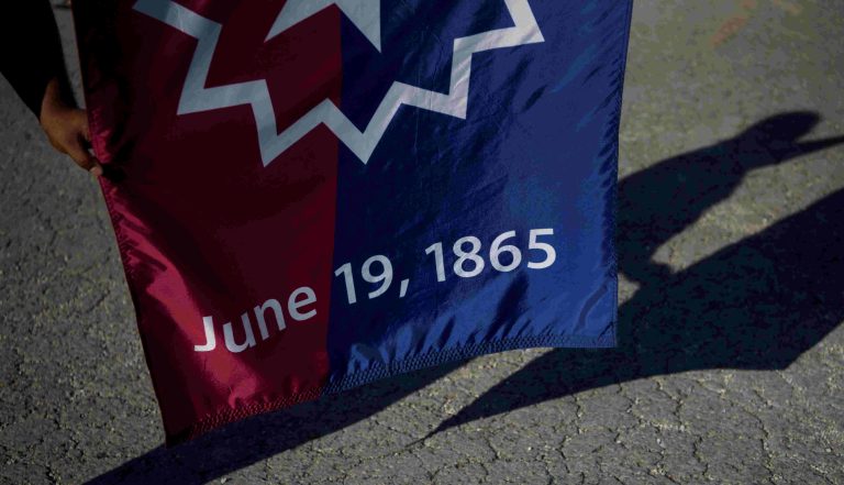A man holds a Juneteenth flag as people gather to celebrate Juneteenth, which commemorates the end of slavery in Texas, two years after the 1863 Emancipation Proclamation freed slaves elsewhere in the United States, in Galveston, Texas, U.S., June 19, 2022. REUTERS/Callaghan O'Hare//File Photo