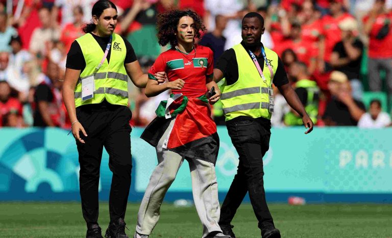 Morocco Beat Argentina In Chaotic Opening Game At Paris Olympics A pitch invader is detained by stewards during the match. REUTERS/Thaier Al-Sudani