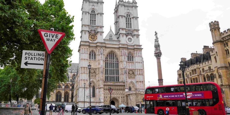 A polling station direction sign is attached to a street sign near to Westminster Abbey, ahead of general elections, in London, Britain July 3, 2024. REUTERS/Maja Smiejkowska