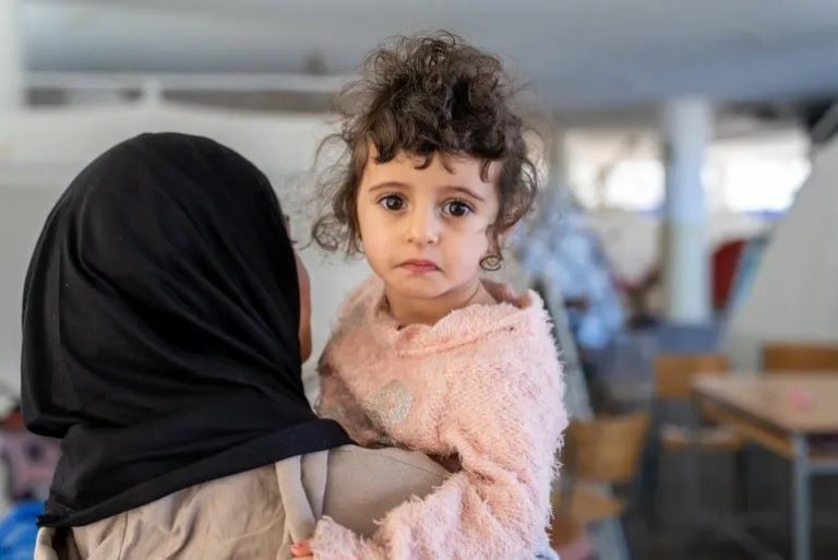 In Lebanon, 2-year old Fatima is held by Fadak, 12, at Omar Faroukh school in Beirut, where hundreds of internally displaced people are currently staying after fleeing violence. Credit: UNICEF/UNI964788/Choufany